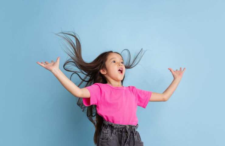 cheveux-etonnes-volants-portrait-petite-fille-caucasienne-mur-bleu-beau-modele-feminin-chemise-rose-concept-emotions-humaines-expression-faciale-jeunesse-enfance